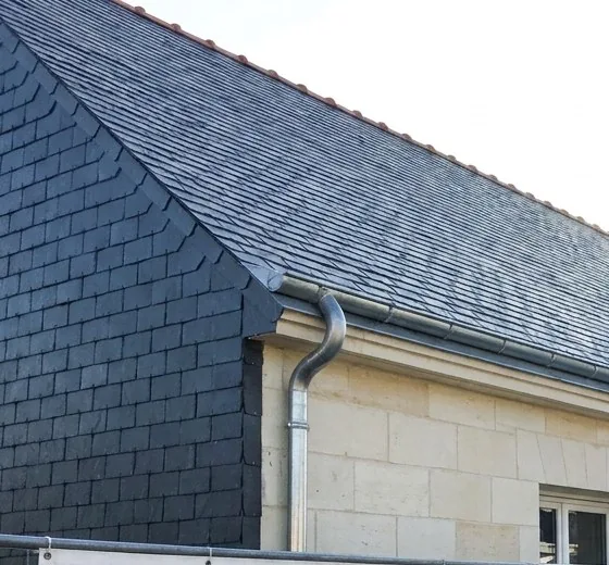 Pignon habillé d'ardoise naturelle et gouttière en zinc neuve sur une maison de Couëron